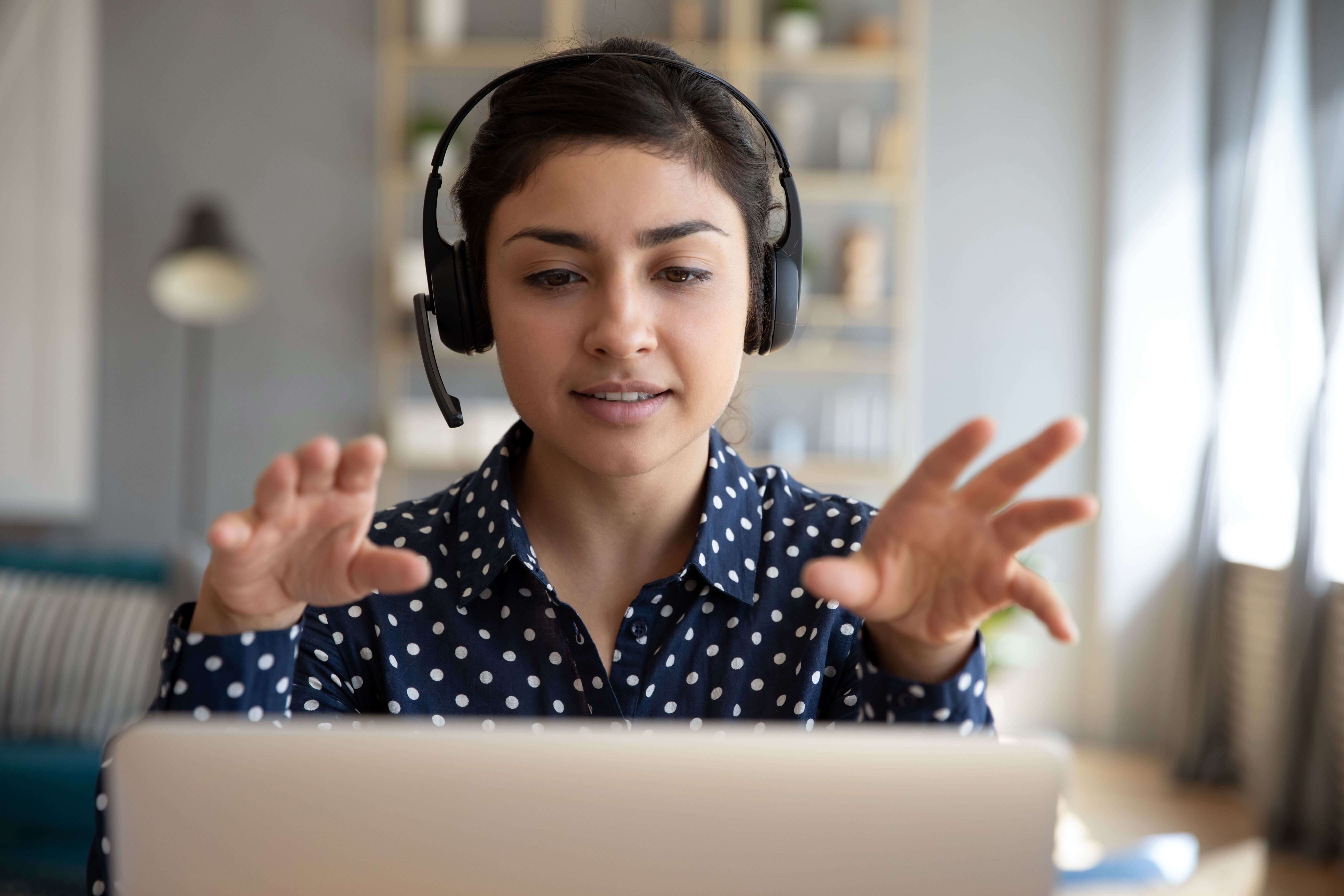 Young Women Talking with Hands in frot of laptop